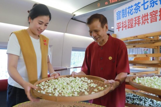 10月1日，福州市茉莉花茶窨制工藝代表性傳承人張子建與旅客在G1634次列車上制作茉莉花茶。新華社記者周義 攝