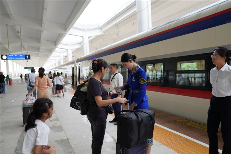 中老鐵路工作人員在站臺(tái)指引旅客進(jìn)站乘車(chē)。老中鐵路有限公司供圖