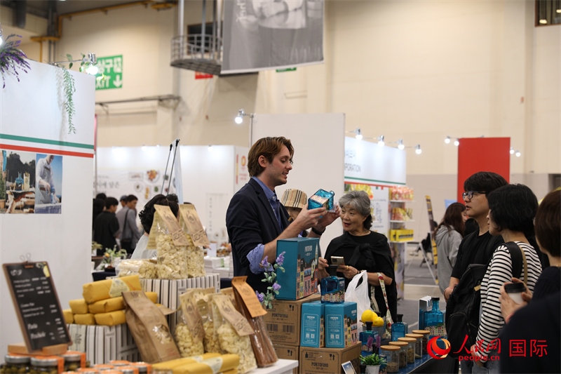 當?shù)貢r間10月5日，在第21屆釜山國際美食博覽會上，意大利展商向參觀者們介紹的意大利食品。人民網(wǎng)記者 莽九晨攝