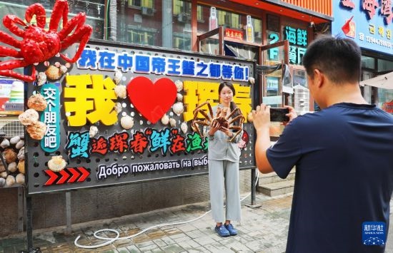 9月21日，游客在吉林省琿春市一處帝王蟹元素主題裝飾前拍照留念。新華社發(fā)