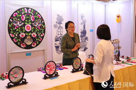 青海非遺文化傳承人向嘉賓介紹展品。人民網(wǎng)實習(xí)生姚欣可攝