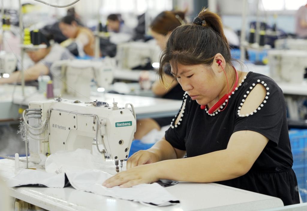 5月20日，村民在李寨村服裝加工廠內(nèi)忙碌。河南省周口市沈丘縣馮營(yíng)鎮(zhèn)李寨村地處豫東平原。近年來(lái)，乘著脫貧攻堅(jiān)與鄉(xiāng)村振興政策的東風(fēng)，李寨村積極探索產(chǎn)業(yè)發(fā)展模式，通過(guò)“龍頭企業(yè)+村集體經(jīng)濟(jì)+農(nóng)戶(hù)”的方式，逐漸發(fā)展形成肉牛養(yǎng)殖、設(shè)施農(nóng)業(yè)、服裝加工、康養(yǎng)民宿等產(chǎn)業(yè)，以產(chǎn)業(yè)振興助力鄉(xiāng)村振興。新華社記者 李嘉南 攝