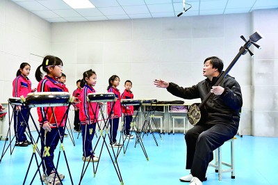 圖為12月30日，在惠民縣胡集鎮(zhèn)第一小學(xué)，老師指導(dǎo)學(xué)生學(xué)習(xí)西河大鼓。新華社記者 郭緒雷攝