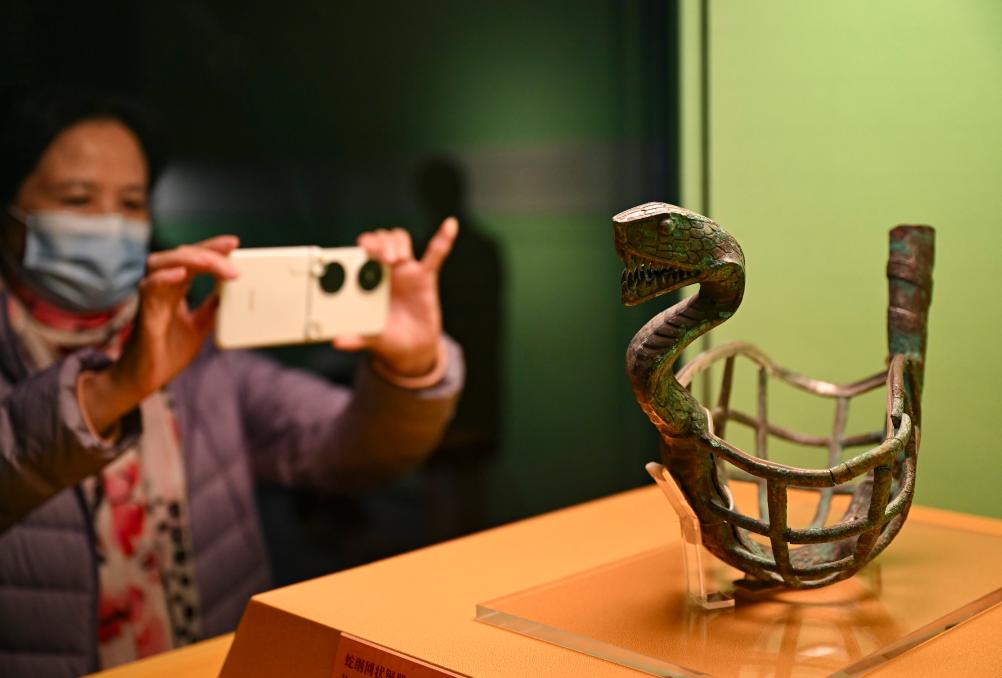 1月14日，觀眾在上海博物館蛇年迎春展拍攝展品蛇綱網(wǎng)狀銅器。新華社發(fā)（陳浩明攝）