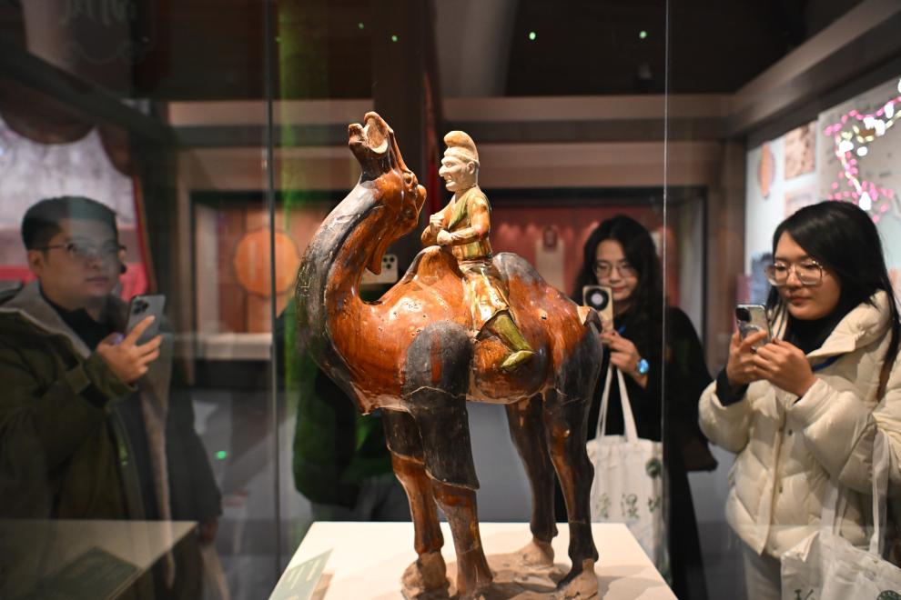 1月15日，觀眾在拍攝“長安三萬里——陜西唐代文物精華展”展出的三彩胡人騎駝俑。（新華社記者 孫凡越 攝）