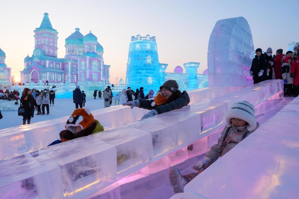 游客在哈爾濱冰雪大世界園區(qū)內(nèi)體驗(yàn)冰滑梯。新華社發(fā)