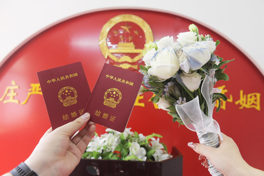 2024年8月10日，一對新人在河北石家莊新樂市民政局婚姻登記處領(lǐng)取結(jié)婚證后拍照留念。新華社發(fā)（賈敏杰攝）