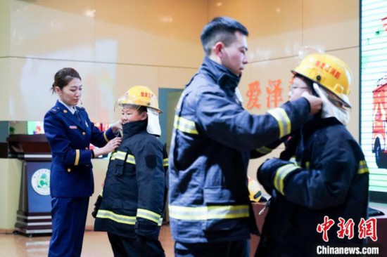 圖為學(xué)生們現(xiàn)場(chǎng)穿戴消防頭盔和戰(zhàn)斗服。中新社記者 趙宇航 攝
