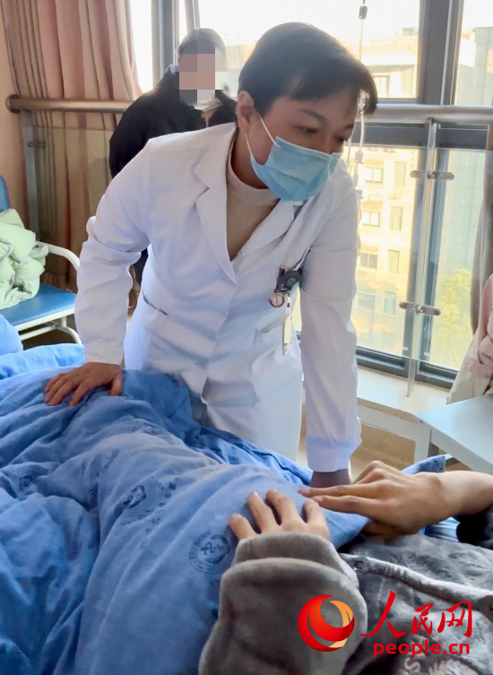 鄧茜查房時詢問患者情況。人民網(wǎng)記者 金慧慧攝