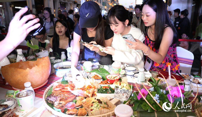 游客拍照打卡體驗(yàn)長桌宴。人民網(wǎng)記者 符武平攝
