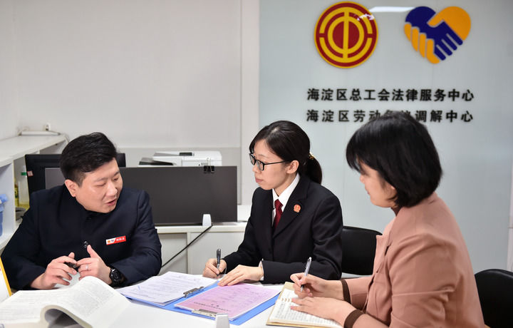 2025年3月6日，在北京市海淀區(qū)總工會勞動爭議調(diào)解中心，海淀區(qū)人民法院法官王琰（中）與該中心工作人員就糾紛化解情況進(jìn)行溝通。新華社記者 趙婷婷 攝