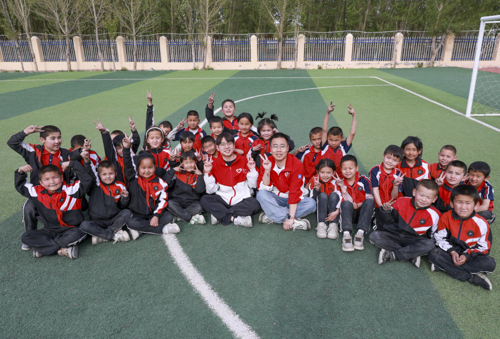 4月23日，在新疆克州阿圖什市哈拉峻鄉(xiāng)謝依特小學，支教教師王俊文（中左）、李軻凡（中右）和學生在一起。