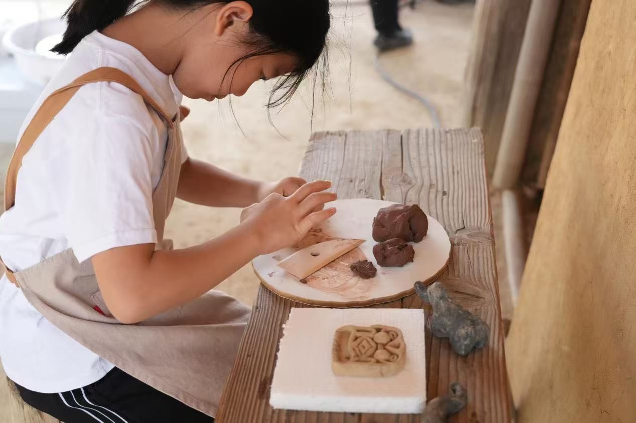 游客制作良渚特色陶藝品。良渚博物院供圖