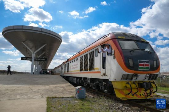 5月31日，在蒙內(nèi)鐵路內(nèi)羅畢站，機(jī)車駕駛員蔣立平（右）和博爾在即將開往蒙巴薩的E2次列車上揮手致意。新華社記者 楊光 攝