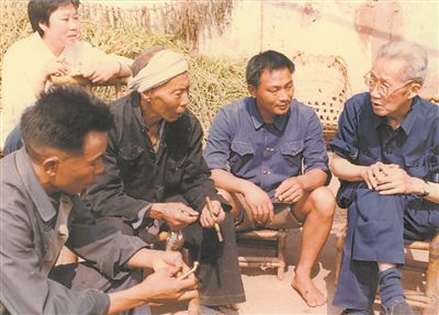 侯光炯（右一）和農(nóng)民在一起親切交流。 西南大學檔案館供圖